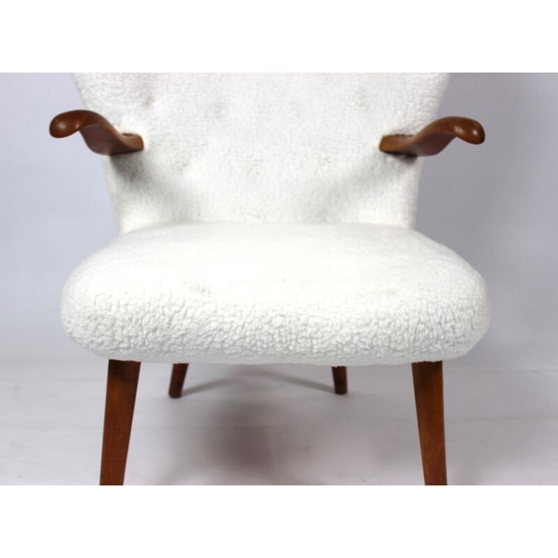 Vintage armchair upholstered with sheep skin and with arms of dark wood 1930s 