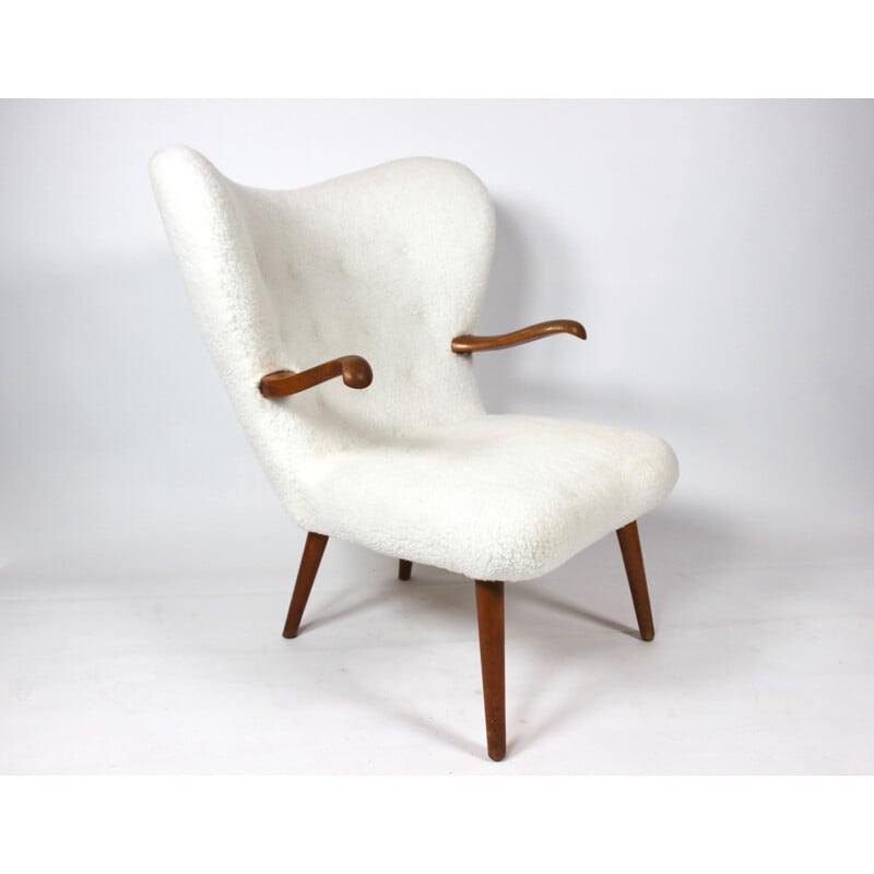 Vintage armchair upholstered with sheep skin and with arms of dark wood 1930s 